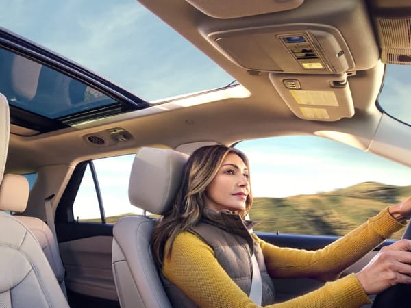 Woman driving Ford Explorer with Moonroof open