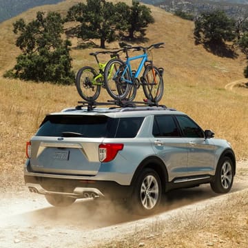 Ford Explorer driving down gravel road.