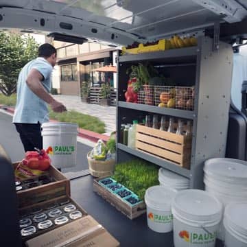 A man loading supplies in to the back of a Ford Transit Connect Cargo Van.