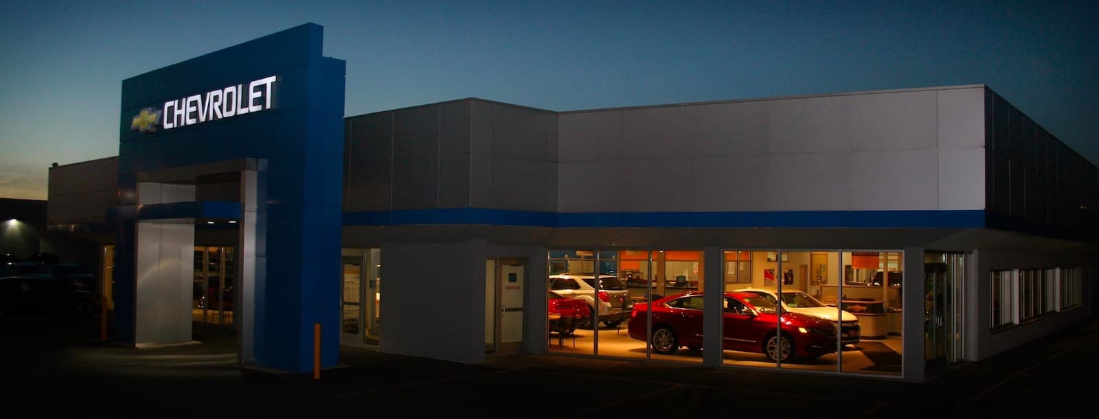 An exterior shot of a Chevrolet dealership at night.