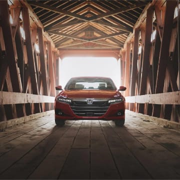 Red Honda Accord parked on wooden bridge facing camera