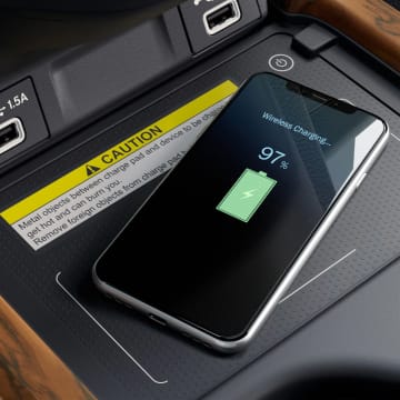 Iphone sitting on wireless charging pad in car