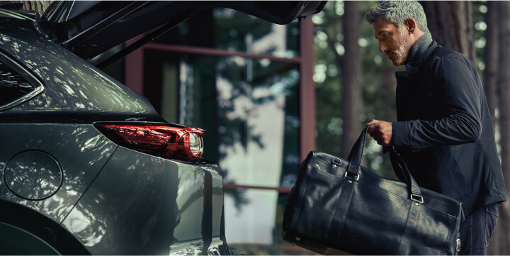 Person putting luggage in back of 2023 Mazda CX-9