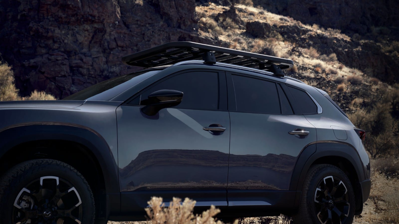Side photo of CX-50 parked with mountain as backdrop