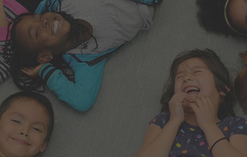 Children lying on the floor laughing