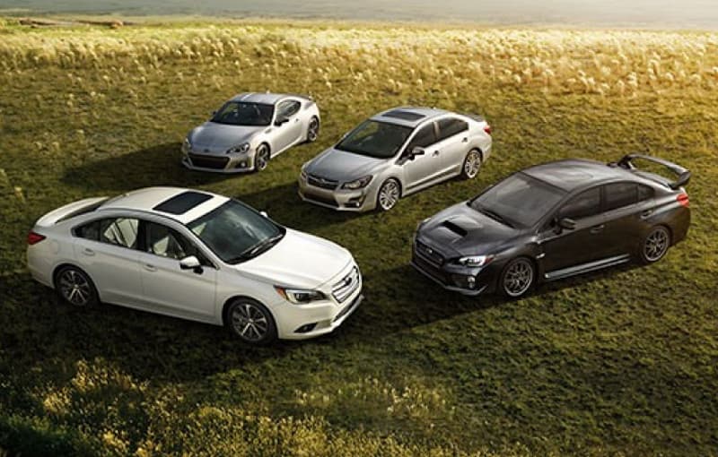 Four Subaru vehicles parked in a field