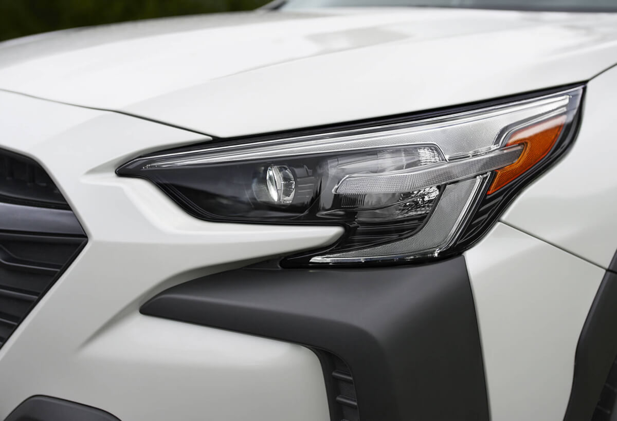 Close-up of the lights, bumper and hood of a Crystal White Pearl 2023 Subaru Vehicle