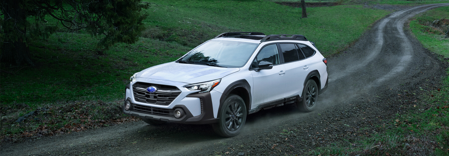 Subaru vehicle driving uphill on a rugged trail.
